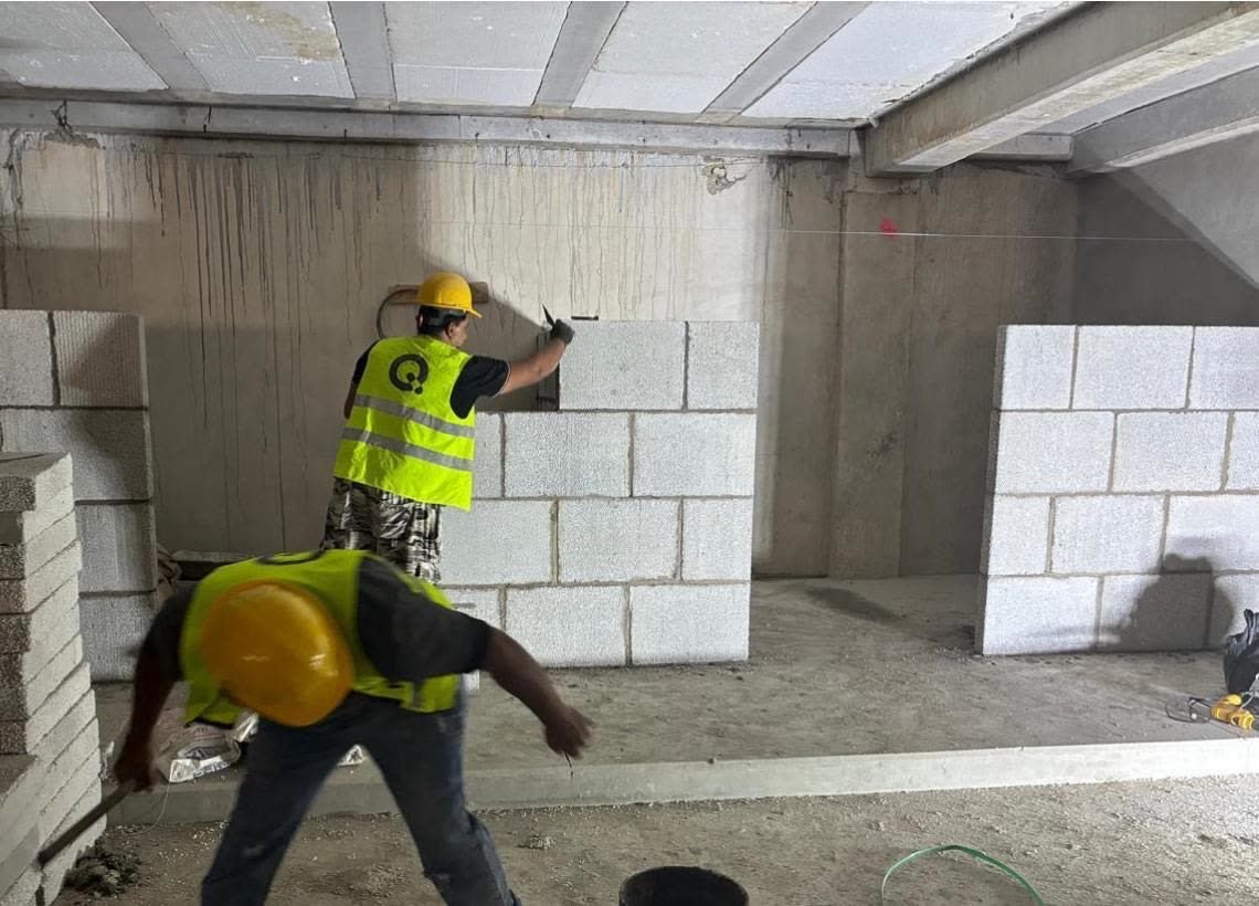 Trabajadores levantando un muro divisorio con bloques de concreto aligerado BLOCKO en obra.