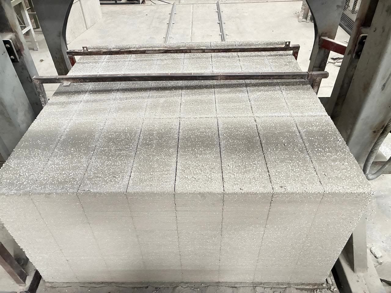 Bloques de concreto aligerado recién cortados en la línea de producción.